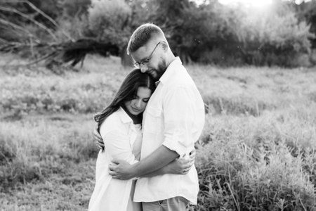 young couple in love a guy with a beard and a girl with dark hair in light clothes in the green forestの写真素材