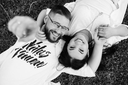 young couple in love a guy with a beard and a girl with dark hair in light clothes in the green forestの写真素材