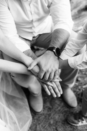 the bride and groom tenderly hold hands between them love and relationshipsの写真素材