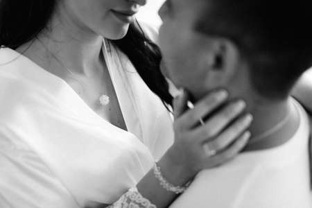 the bride and groom tenderly hold hands between them love and relationshipsの写真素材