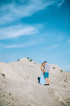 blonde girl in a light blue dress and a guy in a light shirt and short shert in a granite quarryの写真素材