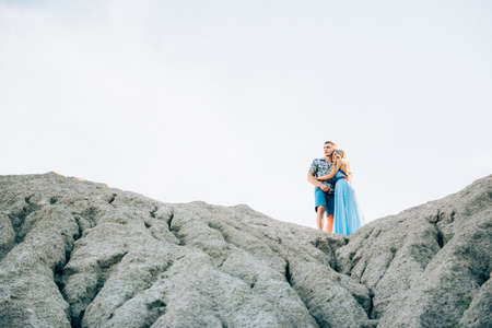 blonde girl in a light blue dress and a guy in a light shirt and short shert in a granite quarryの写真素材