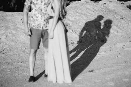 blonde girl in a light blue dress and a guy in a light shirt and short shert in a granite quarry