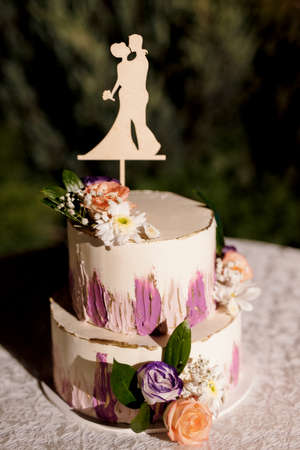 wedding decor with cake on a wooden bench against a waterfall backgroundの写真素材