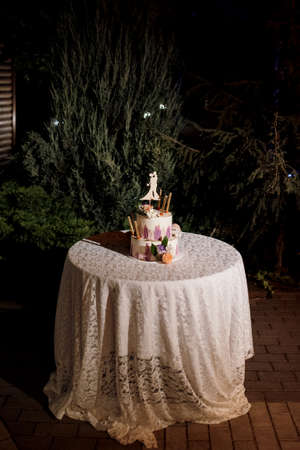 wedding decor with cake on a wooden bench against a waterfall backgroundの写真素材