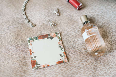 elegant bottle of perfume on the armchair with a pink necklace of the brideの写真素材