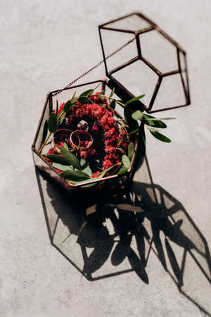 wedding rings in glass box with a red wedding decorの写真素材