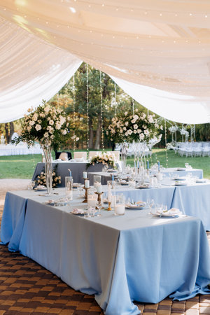 The presidium of the newlyweds in the banquet hall of the restaurant is decorated with candles and green plants, wisteria hangs from the ceilingの写真素材