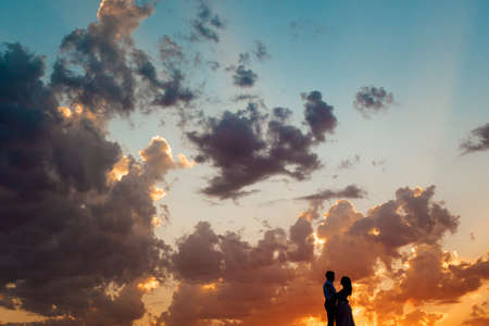 young couple a guy in black breeches and a girl in a pink dress are walking along the white sand of the desertの写真素材