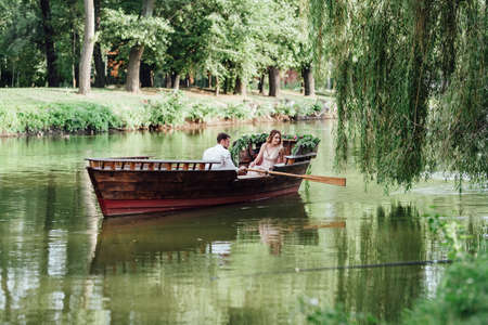 a boat trip for a guy and a girl along the canals and bays of the river overgrown with wild willowsの写真素材