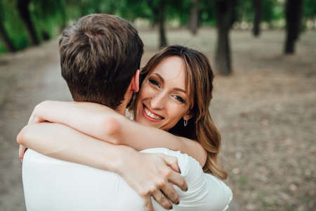 a guy and a girl are walking along the banks of a wild river overgrown with willows and forestの写真素材