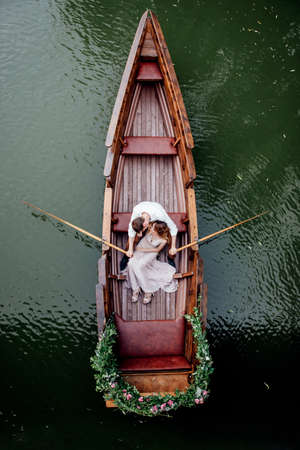 a boat trip for a guy and a girl along the canals and bays of the river overgrown with wild willowsの写真素材