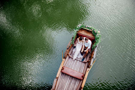 a boat trip for a guy and a girl along the canals and bays of the river overgrown with wild willowsの写真素材