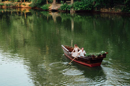 a boat trip for a guy and a girl along the canals and bays of the river overgrown with wild willowsの写真素材