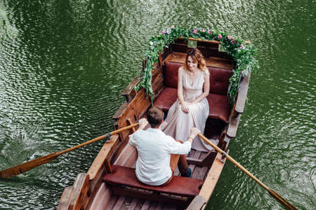 a boat trip for a guy and a girl along the canals and bays of the river overgrown with wild willowsの写真素材