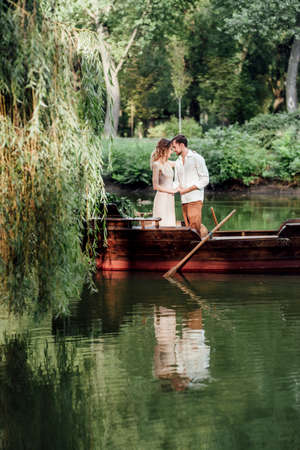 a boat trip for a guy and a girl along the canals and bays of the river overgrown with wild willowsの写真素材