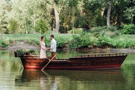 a boat trip for a guy and a girl along the canals and bays of the river overgrown with wild willowsの写真素材