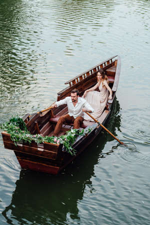 a boat trip for a guy and a girl along the canals and bays of the river overgrown with wild willowsの写真素材