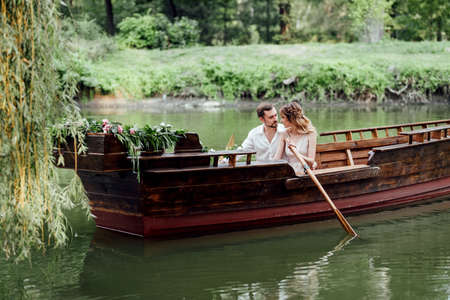 a boat trip for a guy and a girl along the canals and bays of the river overgrown with wild willowsの写真素材