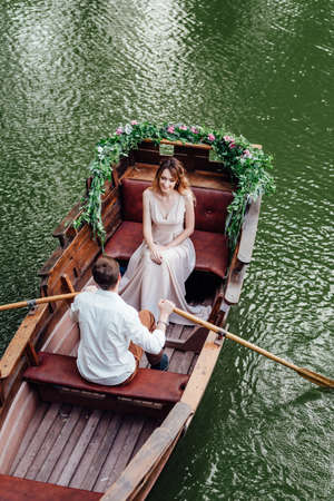 a boat trip for a guy and a girl along the canals and bays of the river overgrown with wild willowsの写真素材