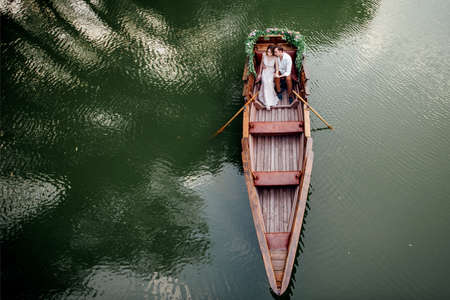 a boat trip for a guy and a girl along the canals and bays of the river overgrown with wild willowsの写真素材