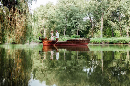 a boat trip for a guy and a girl along the canals and bays of the river overgrown with wild willowsの写真素材