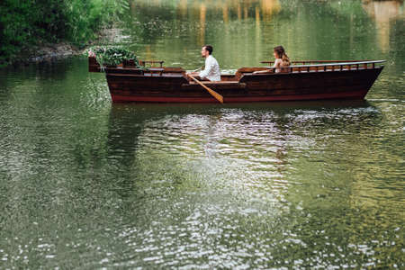a boat trip for a guy and a girl along the canals and bays of the river overgrown with wild willowsの写真素材