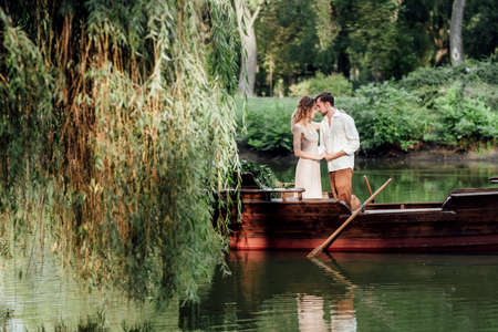 a boat trip for a guy and a girl along the canals and bays of the river overgrown with wild willowsの写真素材
