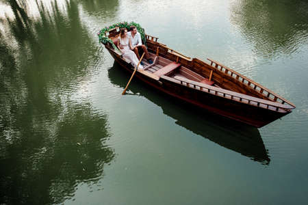 a boat trip for a guy and a girl along the canals and bays of the river overgrown with wild willowsの写真素材