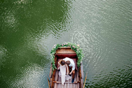 a boat trip for a guy and a girl along the canals and bays of the river overgrown with wild willowsの写真素材