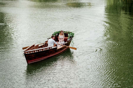 a boat trip for a guy and a girl along the canals and bays of the river overgrown with wild willowsの写真素材