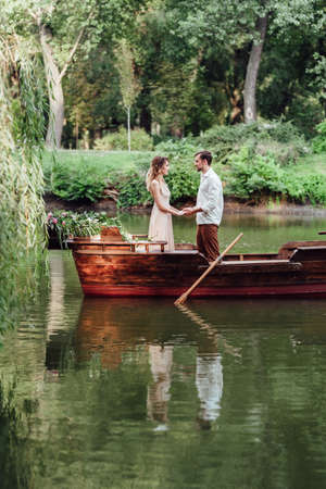 a boat trip for a guy and a girl along the canals and bays of the river overgrown with wild willowsの写真素材