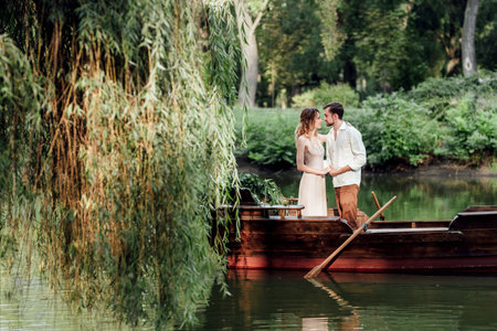 a boat trip for a guy and a girl along the canals and bays of the river overgrown with wild willowsの写真素材