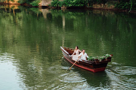 a boat trip for a guy and a girl along the canals and bays of the river overgrown with wild willowsの写真素材