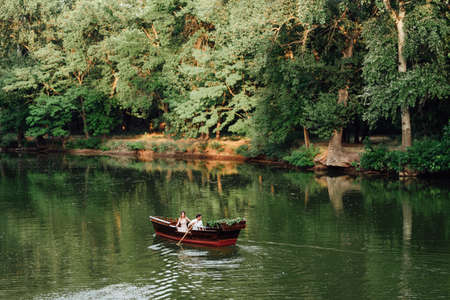 a boat trip for a guy and a girl along the canals and bays of the river overgrown with wild willowsの写真素材