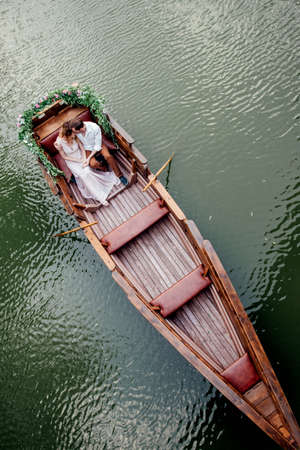 a boat trip for a guy and a girl along the canals and bays of the river overgrown with wild willowsの写真素材