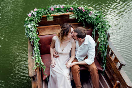 a boat trip for a guy and a girl along the canals and bays of the river overgrown with wild willowsの写真素材