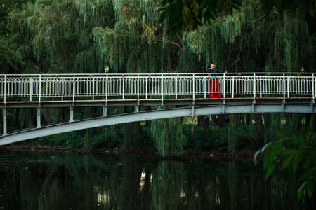 Girl model with white hair in a retro dress with ruffles in a green parkの写真素材