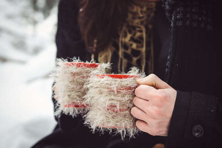 A guy and a girl in warm clothes and scarves on a walk in the snowy forest and in the fieldの写真素材