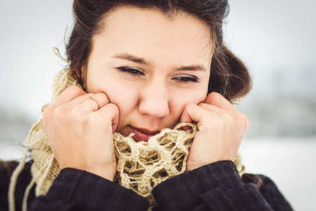girl in warm clothes and scarves on a walk in the snowy forest and in the fieldの写真素材