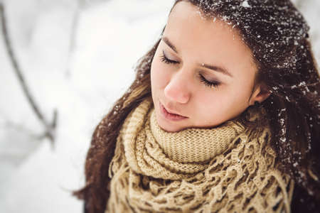 girl in warm clothes and scarves on a walk in the snowy forest and in the fieldの写真素材