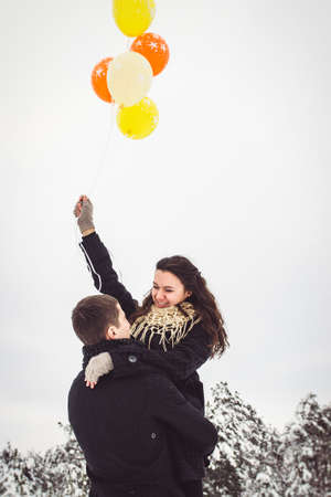 A guy and a girl in warm clothes and scarves on a walk in the snowy forest and in the fieldの写真素材