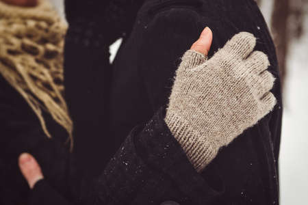 A guy and a girl in warm clothes and scarves on a walk in the snowy forest and in the fieldの写真素材