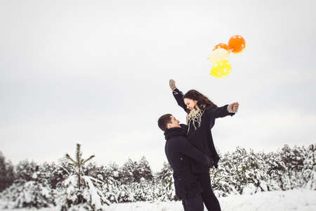 A guy and a girl in warm clothes and scarves on a walk in the snowy forest and in the fieldの写真素材