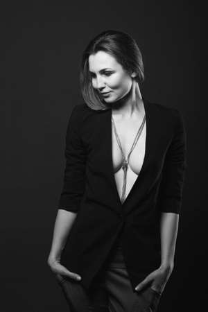 girl brunette beauty model in a black jacket on a dark blue backgroundの写真素材