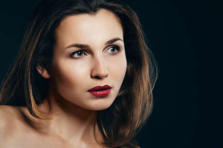 girl brunette beauty model in a black jacket on a dark blue backgroundの写真素材