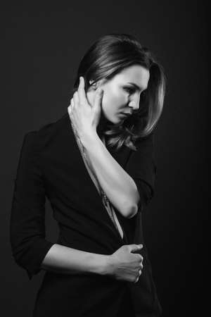 girl brunette beauty model in a black jacket on a dark blue backgroundの写真素材