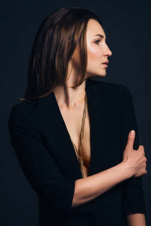 girl brunette beauty model in a black jacket on a dark blue backgroundの写真素材