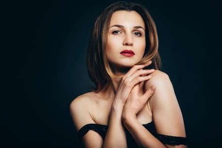 girl brunette beauty model in a black jacket on a dark blue backgroundの写真素材