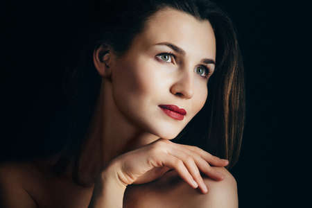 girl brunette beauty model in a black jacket on a dark blue backgroundの写真素材